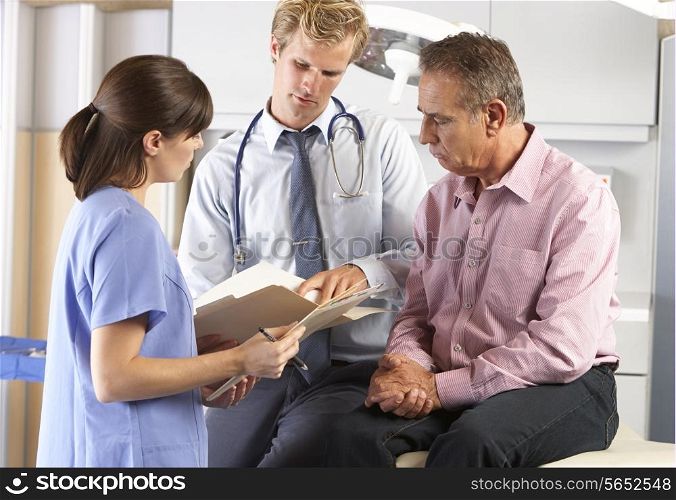 Male Patient Being Examined By Doctor And Intern