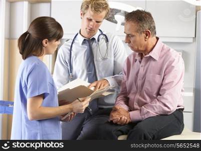 Male Patient Being Examined By Doctor And Intern