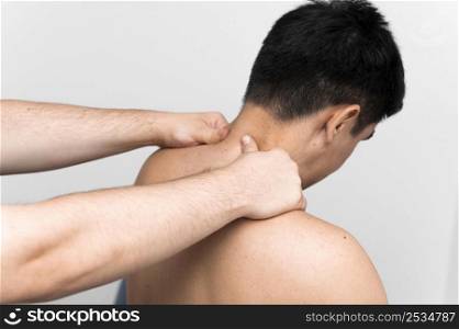 male patient getting neck massage from physiotherapist