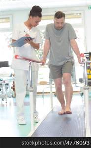 male patient standing with a physiotherapist