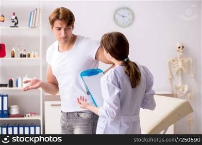 Male patient visiting young female doctor chiropractor 