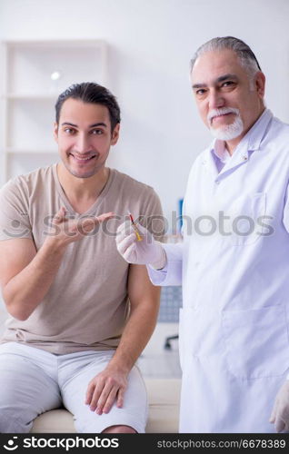 Male patient visitng doctor for shot inoculation 