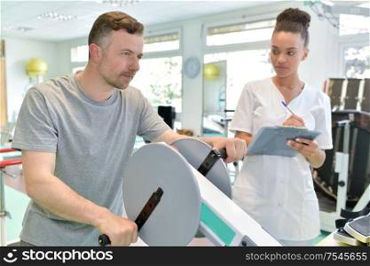 male patient with female physio therapist working out arms