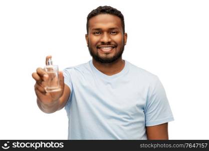 male perfumery, grooming and people concept - happy smiling young african american man with perfume over white background. happy african american man with perfume