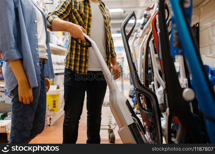 Male person hand holds vacuum cleaner in electronics store. Man buying home electrical appliances in market. Male hand holds vacuum cleaner, electronics store