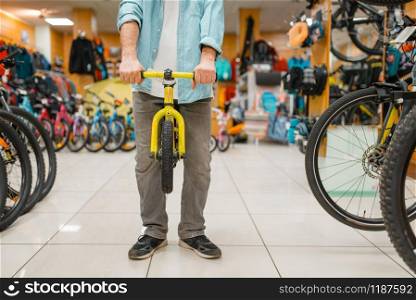 Male person with children&rsquo;s bicycle, shopping in sports shop. Summer season extreme lifestyle, active leisure store, customer buying cycle for family riding