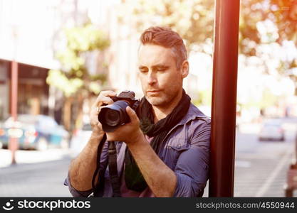 Male photographer taking picture. Professional photographer taking picture in city