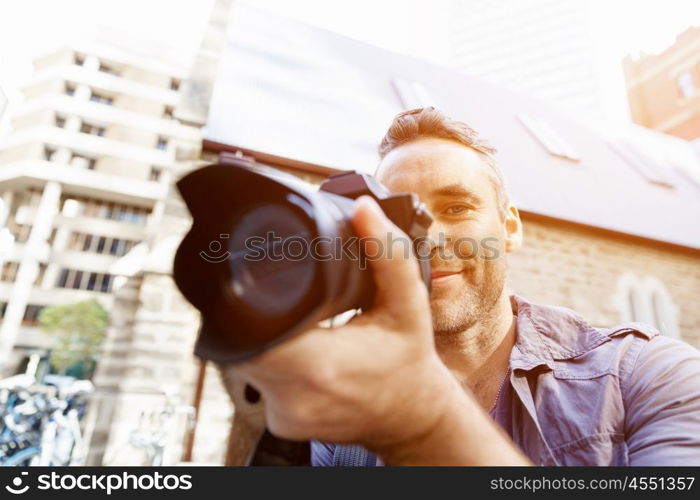 Male photographer taking picture. Professional photographer taking picture in city