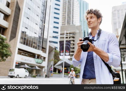 Male photographer taking picture. Professional photographer taking picture in city