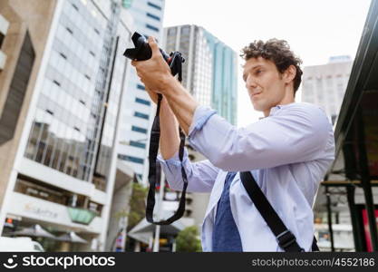 Male photographer taking picture. Professional photographer taking picture in city