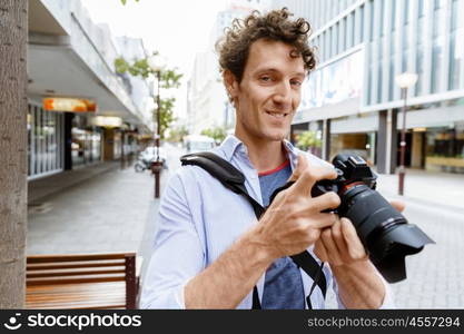 Male photographer taking picture. Professional photographer taking picture in city