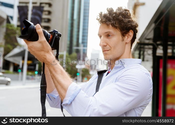 Male photographer taking picture. Professional photographer taking picture in city