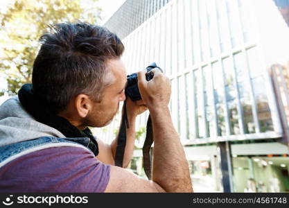 Male photographer taking picture. Professional photographer taking picture in city