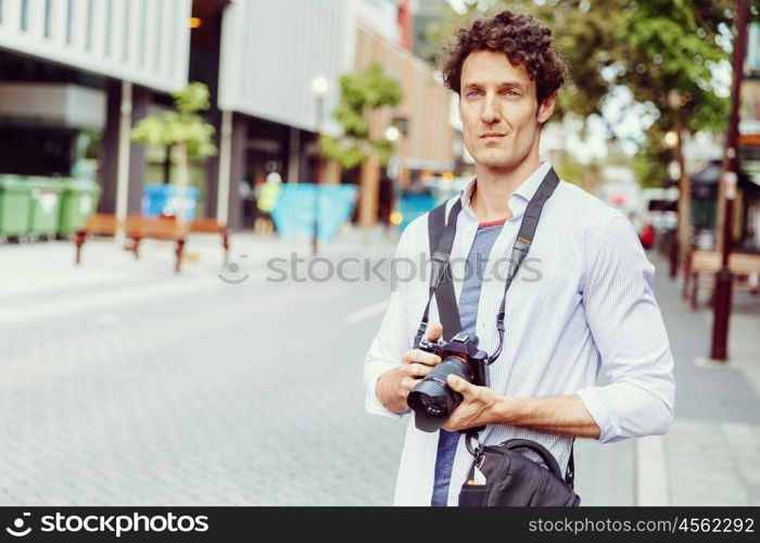 Male photographer taking picture. Professional photographer taking picture in city