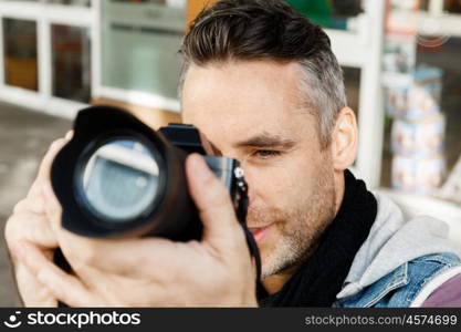 Male photographer taking picture. Professional photographer taking picture in city