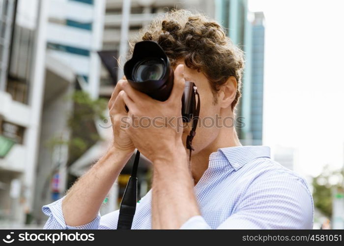 Male photographer taking picture. Professional photographer taking picture in city