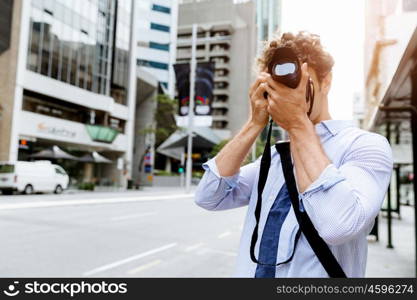 Male photographer taking picture. Professional photographer taking picture in city