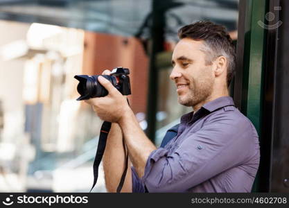 Male photographer taking picture. Professional photographer taking picture in city