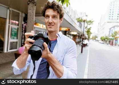 Male photographer taking picture. Professional photographer taking picture in city