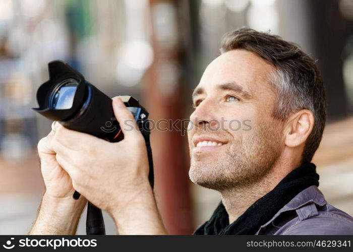 Male photographer taking picture. Professional photographer taking picture in city