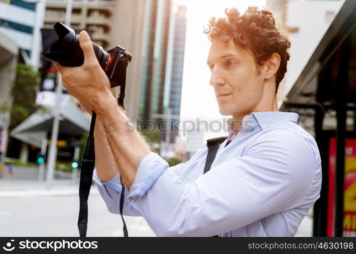 Male photographer taking picture. Professional photographer taking picture in city