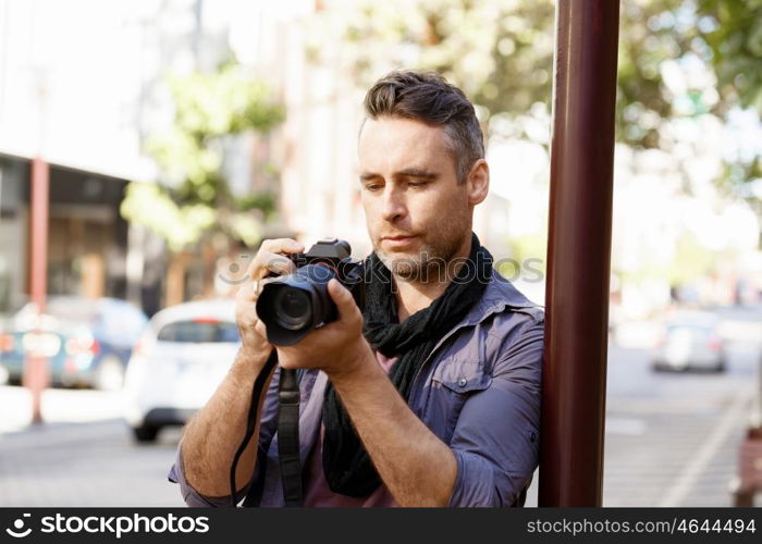 Male photographer taking picture. Professional photographer taking picture in city