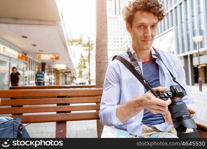 Male photographer taking picture. Professional photographer taking picture in city