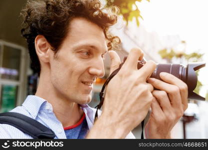 Male photographer taking picture. Professional photographer taking picture in city