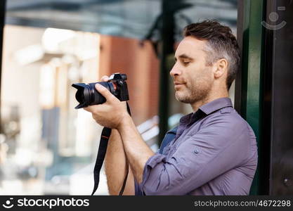 Male photographer taking picture. Professional photographer taking picture in city