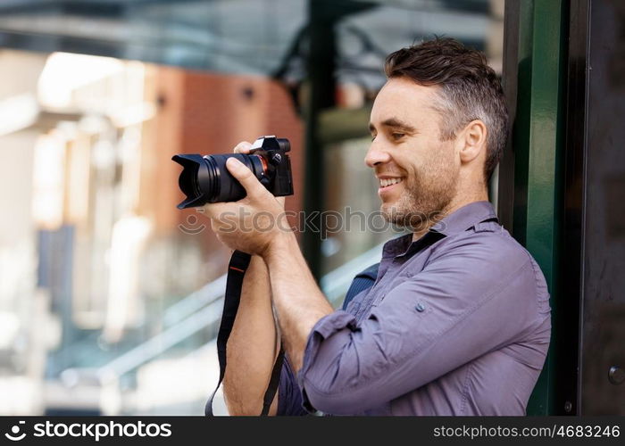 Male photographer taking picture. Professional photographer taking picture in city