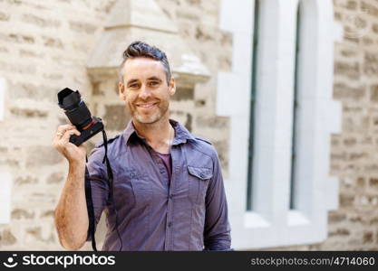 Male photographer taking picture. Professional photographer taking picture in city