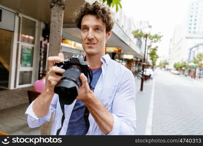 Male photographer taking picture. Professional photographer taking picture in city