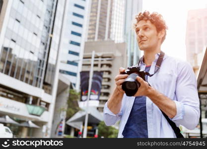 Male photographer taking picture. Professional photographer taking picture in city