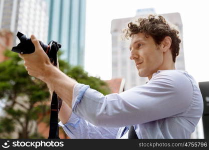 Male photographer taking picture. Professional photographer taking picture in city