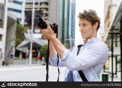 Male photographer taking picture. Professional photographer taking picture in city