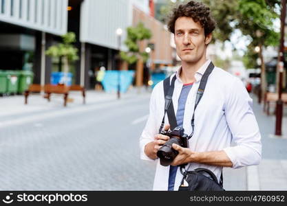 Male photographer taking picture. Professional photographer taking picture in city