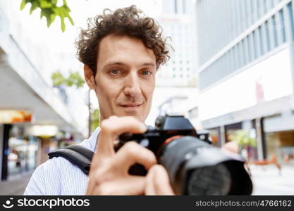 Male photographer taking picture. Professional photographer taking picture in city