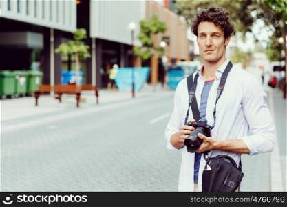 Male photographer taking picture. Professional photographer taking picture in city