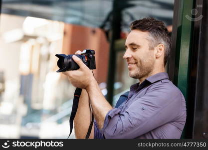 Male photographer taking picture. Professional photographer taking picture in city