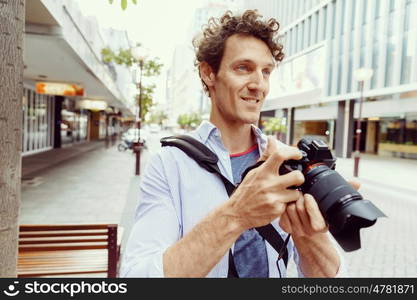 Male photographer taking picture. Professional photographer taking picture in city