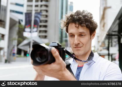 Male photographer taking picture. Professional photographer taking picture in city