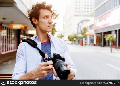 Male photographer taking picture. Professional photographer taking picture in city