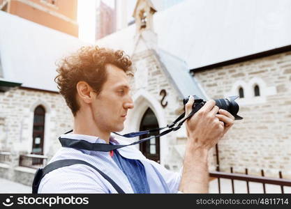 Male photographer taking picture. Professional photographer taking picture in city