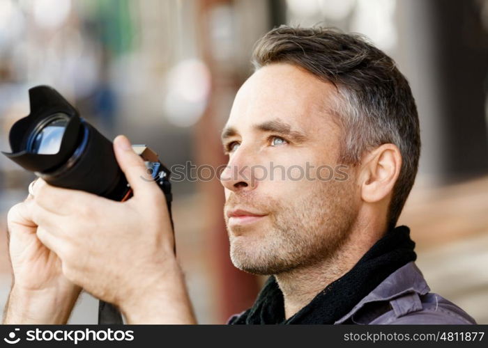 Male photographer taking picture. Professional photographer taking picture in city