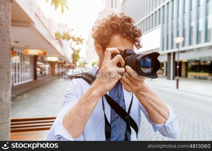 Male photographer taking picture. Professional photographer taking picture in city