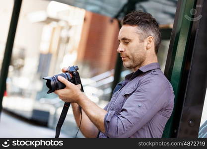 Male photographer taking picture. Professional photographer taking picture in city