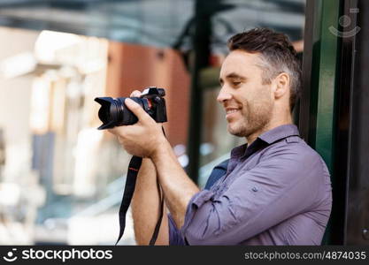 Male photographer taking picture. Professional photographer taking picture in city