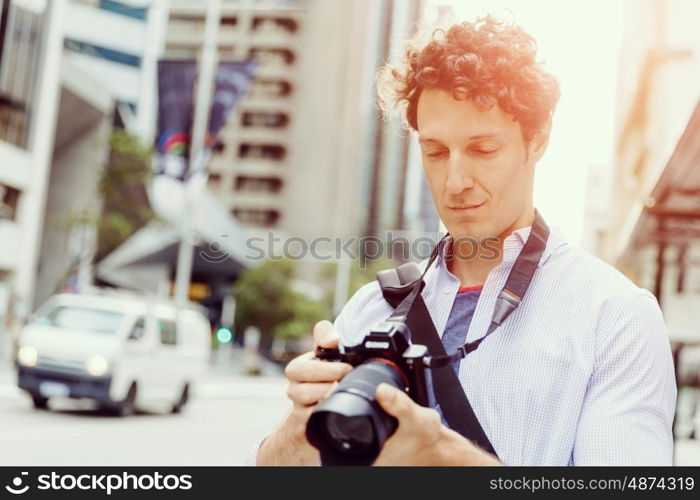 Male photographer taking picture. Professional photographer taking picture in city