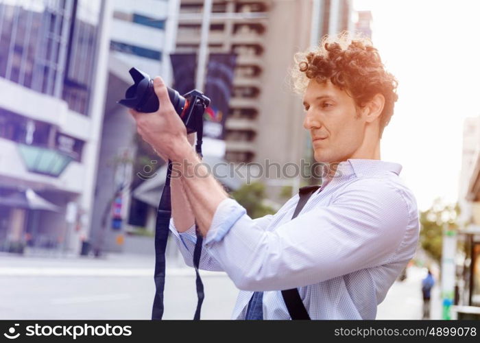 Male photographer taking picture. Professional photographer taking picture in city