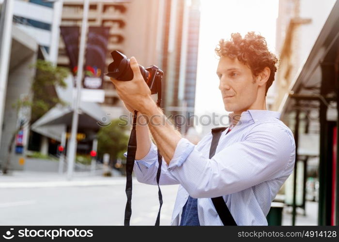 Male photographer taking picture. Professional photographer taking picture in city